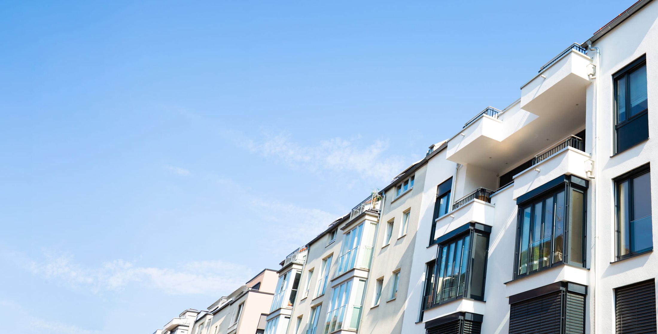 Moderne Wohnanlage und Mehrfamilienhäuser unter blauem Himmel
